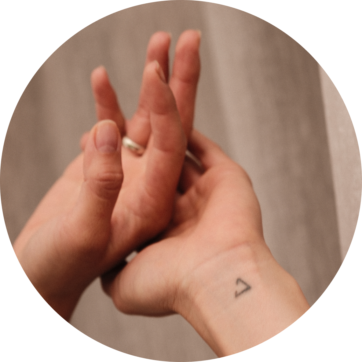 Female hands with a wedding ring and minor tattoo on the right wrist after applying Cirqadian products.